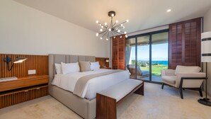 Une chambre moderne avec un grand lit, un bureau, une chaise et une vue sur l’extérieur.