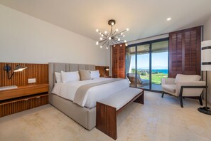 A modern bedroom with a large bed, a desk, a chair, and a view of the outdoors. - Condo Sardan 3BD - Tau Punta Mita (Punta de Mita)
