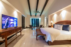 A hotel room with a bed, a TV, a desk, and a ceiling fan. - Condo Jazmin 4BD - Hacienda De Mita Punta Mita (Punta de Mita)