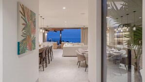 Un interno moderno con zona pranzo, divano e vista sull'oceano.