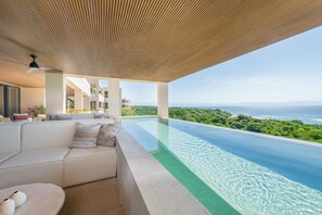 A modern infinity pool with a clear view of the ocean and greenery. - Condo Surf 4BD - Surf Punta Mita (Punta de Mita)