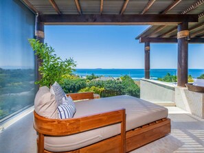 A wooden bench with cushions and a view of the ocean. - Casa Escrita 3BD - Tau Punta Mita (Punta de Mita)