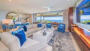 A spacious living room with a large sofa, coffee table, and a view of the ocean. - Casa Escrita 3BD - Tau Punta Mita (Punta de Mita)