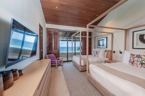 Ein modernes Schlafzimmer mit einem großen Bett, einem Schreibtisch und Blick aufs Meer.