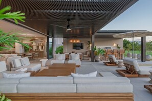 A modern outdoor living area with a wooden ceiling, seating arrangements, and a view of the surrounding landscape. - Villa Buena Vida 4BD - Porta Fortuna Punta Mita (Punta de Mita)