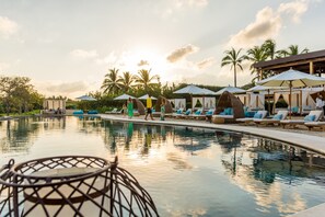 A poolside area with lounge chairs, umbrellas, and a clear sky. - Villa Amada 5BD - Porta Fortuna Punta Mita (Punta de Mita)