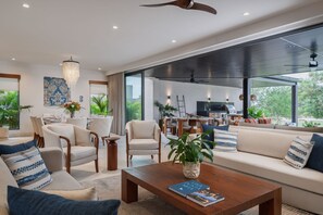 A modern living room with a sofa, chairs, a coffee table, and a dining area with a table and chairs. - Villa Amada 5BD - Porta Fortuna Punta Mita (Punta de Mita)
