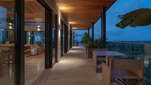 A covered outdoor area with a view of the landscape, furnished with tables and chairs. - Casa Tuki 6BD - Las Vistas Punta Mita (Punta de Mita)