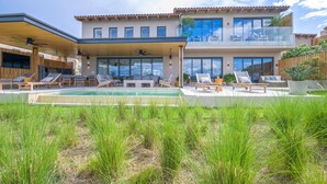 A modern two-story house with a swimming pool, outdoor seating, and a covered patio area. - Villa Cielo Azul 4BD - Iyari Punta Mita (Punta de Mita)