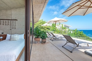 A bedroom with a bed, a nightstand, and a wall-mounted shelf with decorative items. - Casa Morgandez 5BD - Iyari Punta Mita (Punta de Mita)