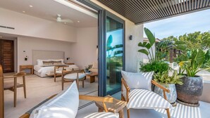 Un interior moderno con sala de estar, un dormitorio y un balcón con plantas.