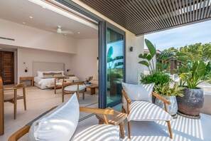 A modern interior with a living area, a bedroom, and a balcony with plants. - Villa Amistad 4BD - Porta Fortuna Punta Mita (Punta de Mita)