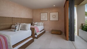 Un dormitorio con dos camas, un cabecero de madera, un aparador y dos cuadros en la pared.