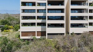 Un edificio de varios pisos con balcones, ventanas amplias y techo plano.