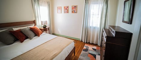 A bedroom with a bed, a dresser, and a nightstand.