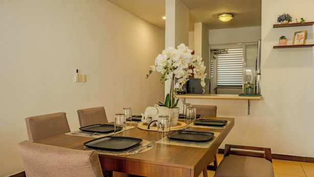 A dining area with a wooden table set for four, surrounded by chairs. - Acapulco Getaway Pool & Jacuzzi 2 BR (Acapulco de Juárez)