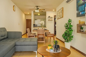 A living room with a grey sectional sofa, a wooden coffee table, and a potted plant. - Acapulco Getaway Pool & Jacuzzi 2 BR (Acapulco de Juárez)