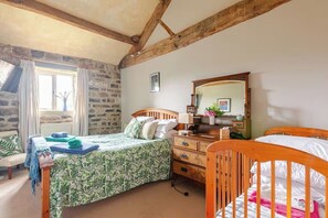 A bedroom with a bed, a dresser, a mirror, and a crib. - Dowgill 3-Bed Barn Sleeps7 HotTub&Parking (Harrogate)