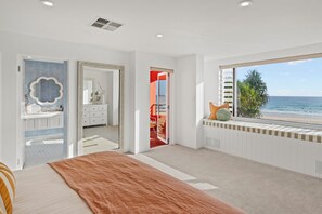 A bedroom with a large bed, a bathroom with a mirror, and a view of the beach. - The Beachhouse by Sandbox - Entire Luxury Beachfront Home with Sauna and Steam Shower in Palm Beach (Palm Beach)