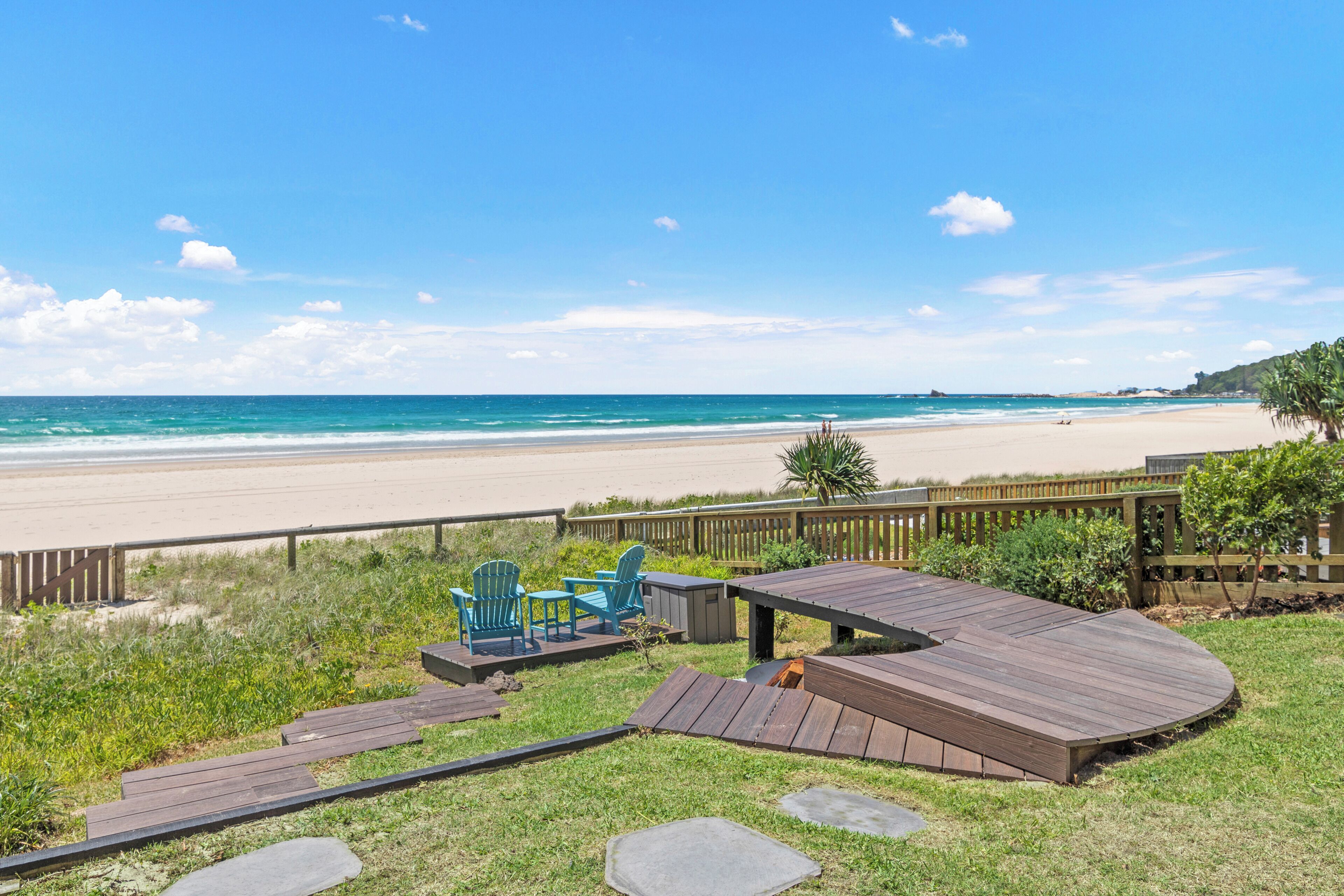 Une terrasse avec des sièges extérieurs donnant sur une plage.