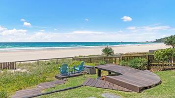 Une terrasse avec des sièges extérieurs donnant sur une plage.