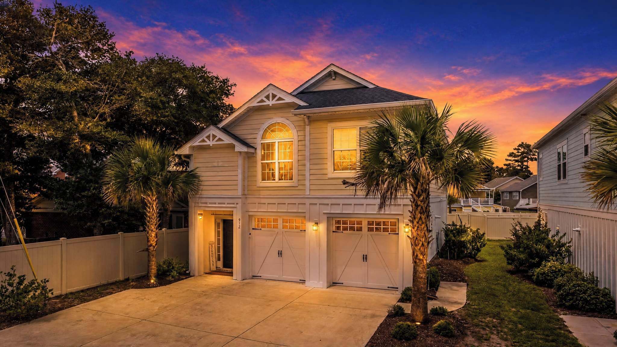 A two-story house with a garage, a driveway, and a well-maintained lawn.