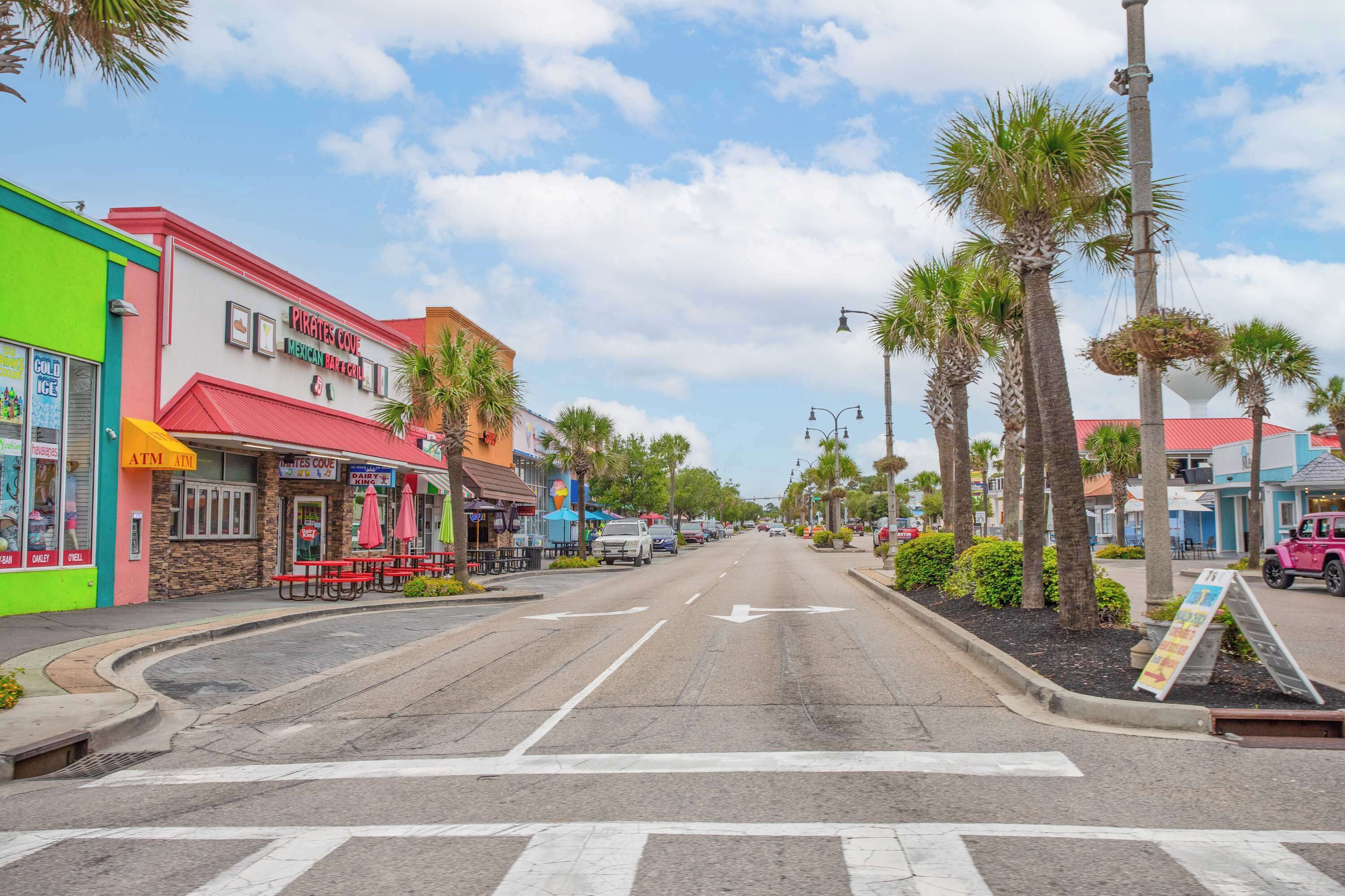 Eine Straße mit einer Reihe bunter Gebäude, darunter ein Restaurant namens 'Pirates Cove Mexican Bar & Grill'.