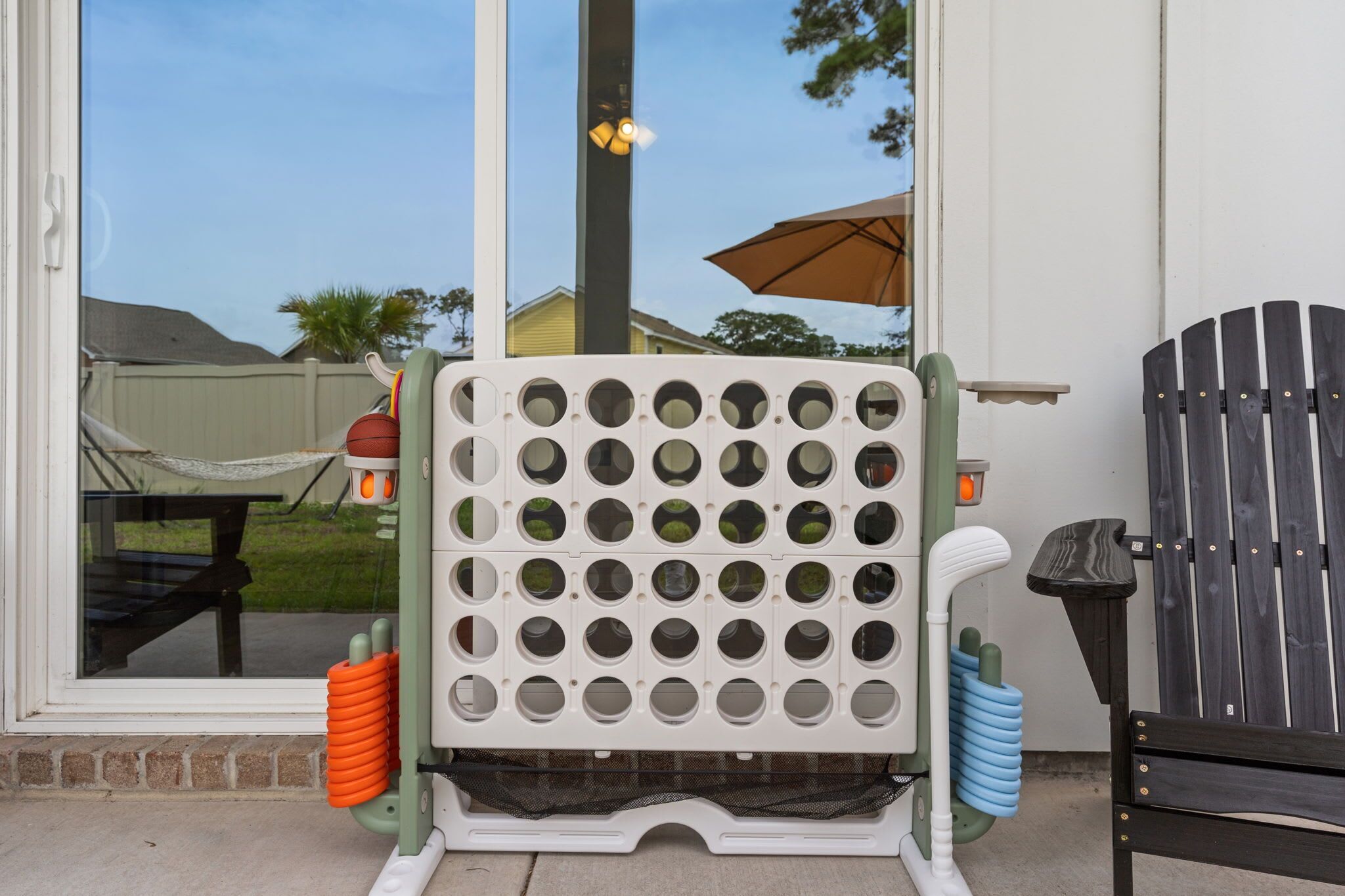 A patio area with a play structure, a chair, and a table.