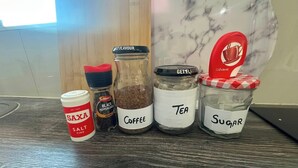 Four glass jars labeled with different contents on a wooden surface.