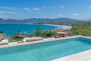 A clear blue pool with lounge chairs and a table, overlooking a beach and mountains. - Casa Yeiy 7BD - Kupuri Punta Mita (Punta de Mita)