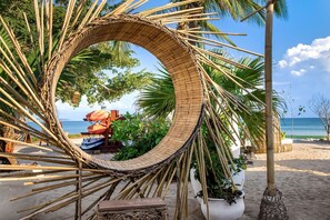 A circular bamboo structure on a beach with a view of the sea and a lounge area with umbrellas. - PH Prima Vista 4BD - Tau Punta Mita (Punta de Mita)