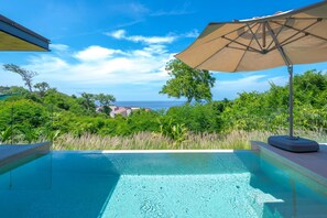 Una piscina con vista sul mare e sul verde.