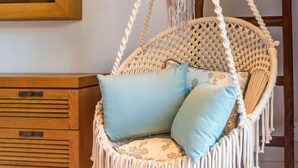 A macrame hanging chair with cushions, a wooden cabinet, and a hat on a wooden ladder. - Mataiza 5BD - Iyari Punta Mita (Punta de Mita)