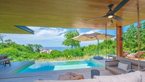 A pool area with a view of the ocean, a ceiling fan, and outdoor furniture. - Mataiza 5BD - Iyari Punta Mita (Punta de Mita)