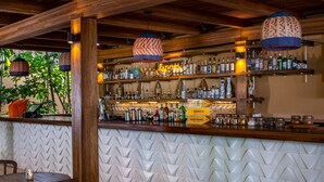 A bar with wooden beams, hanging lamps, and a variety of liquor bottles. - Rooftop Oasis 5BD - Surf Punta Mita (Punta de Mita)