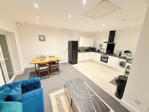 A modern kitchen with white cabinets, a black refrigerator, and a microwave. - 7 Guests 3-Br free parking-near Manchester Airport (Cheadle)