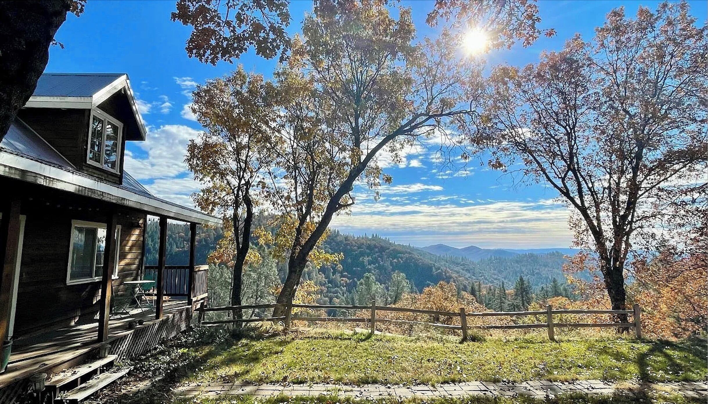 Une cabane dotée d’une véranda donnant sur un paysage montagneux.