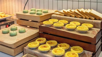 Diversos doces e pastelaria expostos em suportes de madeira.