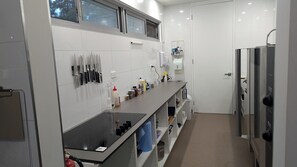 A modern kitchen with a black countertop, white cabinets, and a window above the sink. - Masked Owl Retreat offers boutique accommodation nestled in the Otway Forest. (Forrest)
