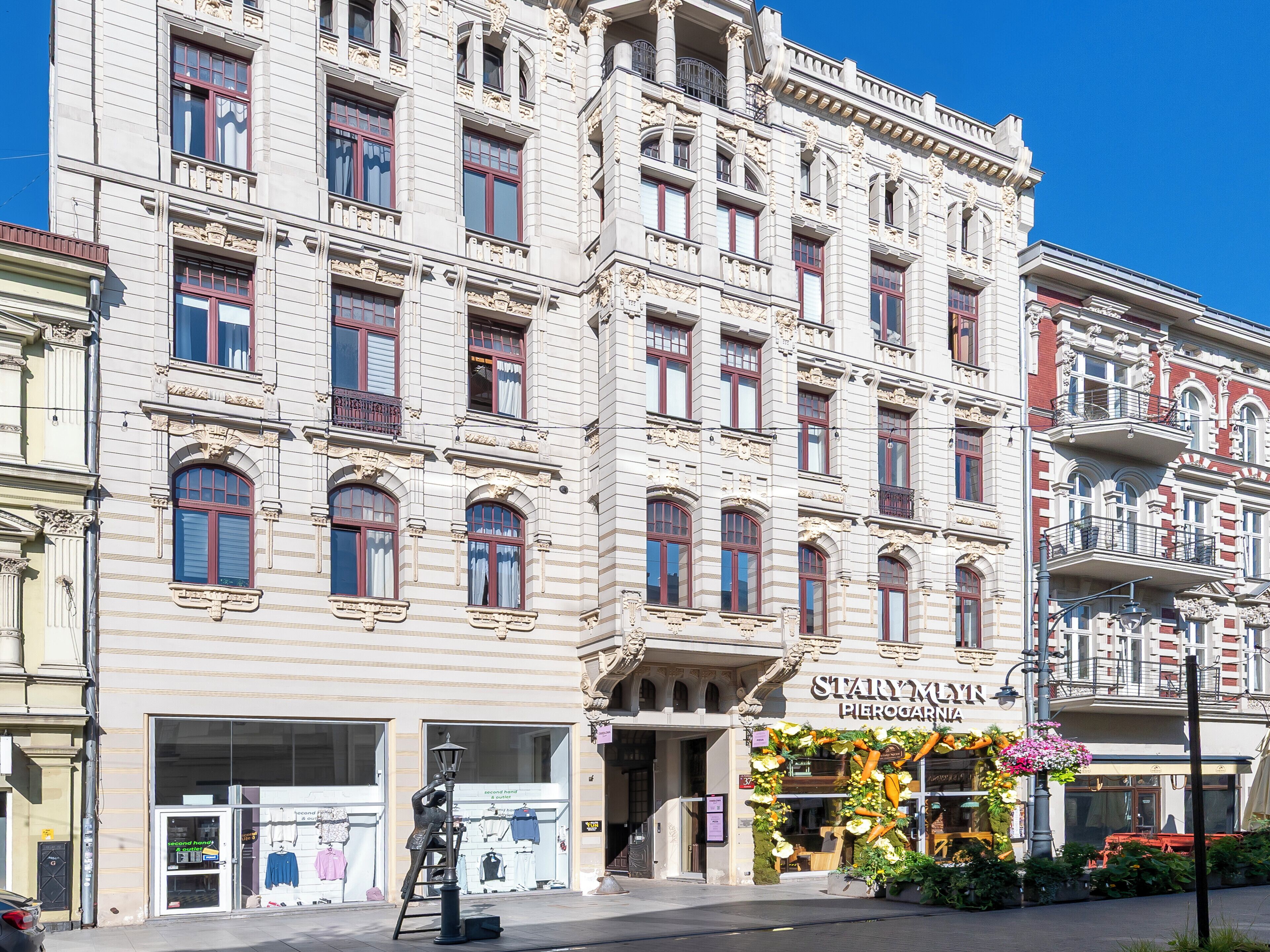 A historic building with ornate architectural details, a storefront with a floral display, and a street lamp.