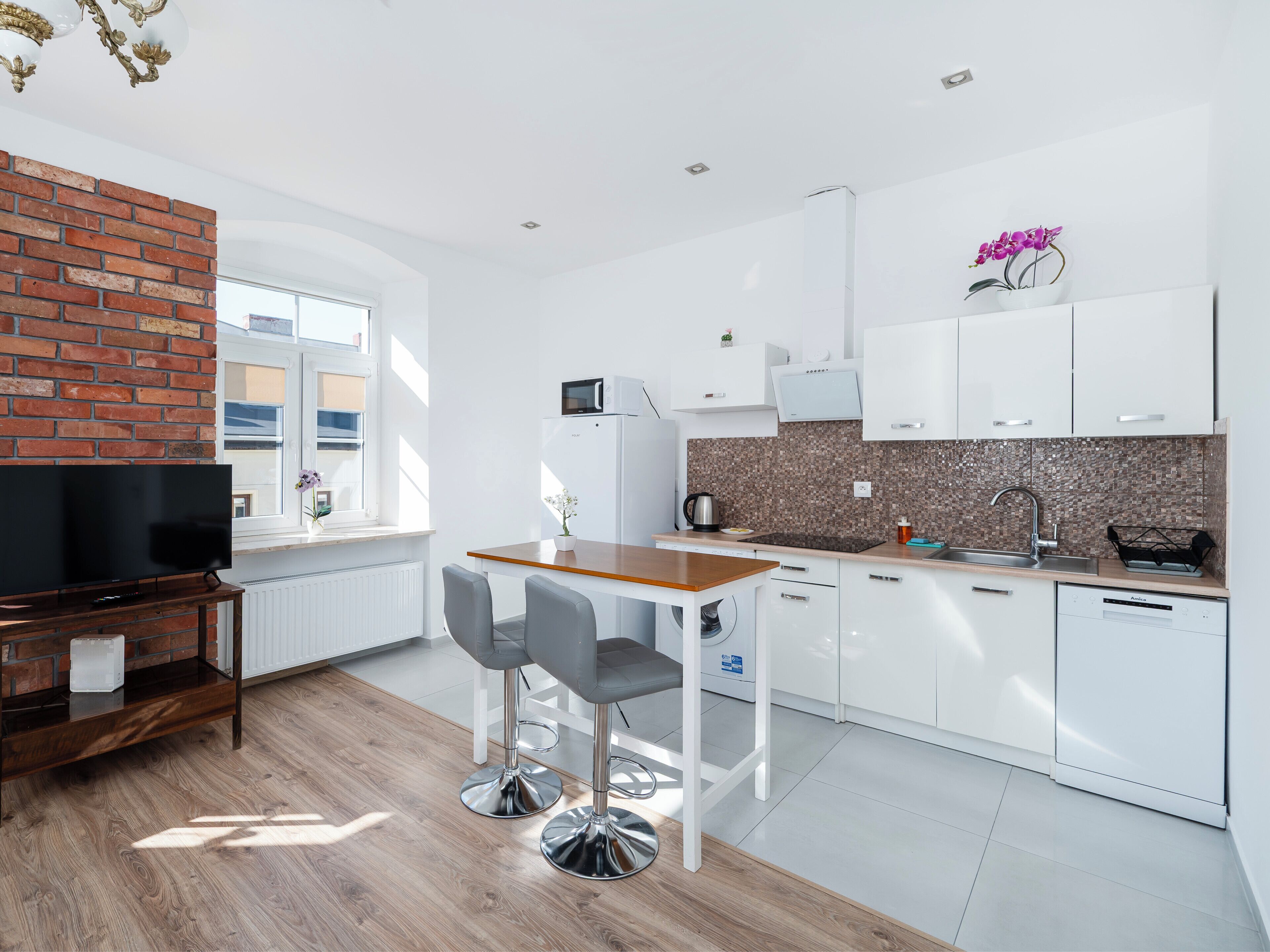 A modern kitchen with white cabinets, a wooden countertop, and a built-in oven.