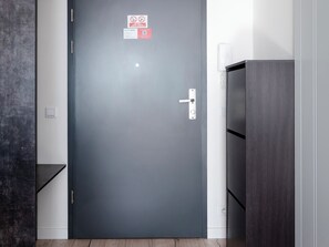 Puerta cerrada con manija y un letrero que indica prohibido fumar.