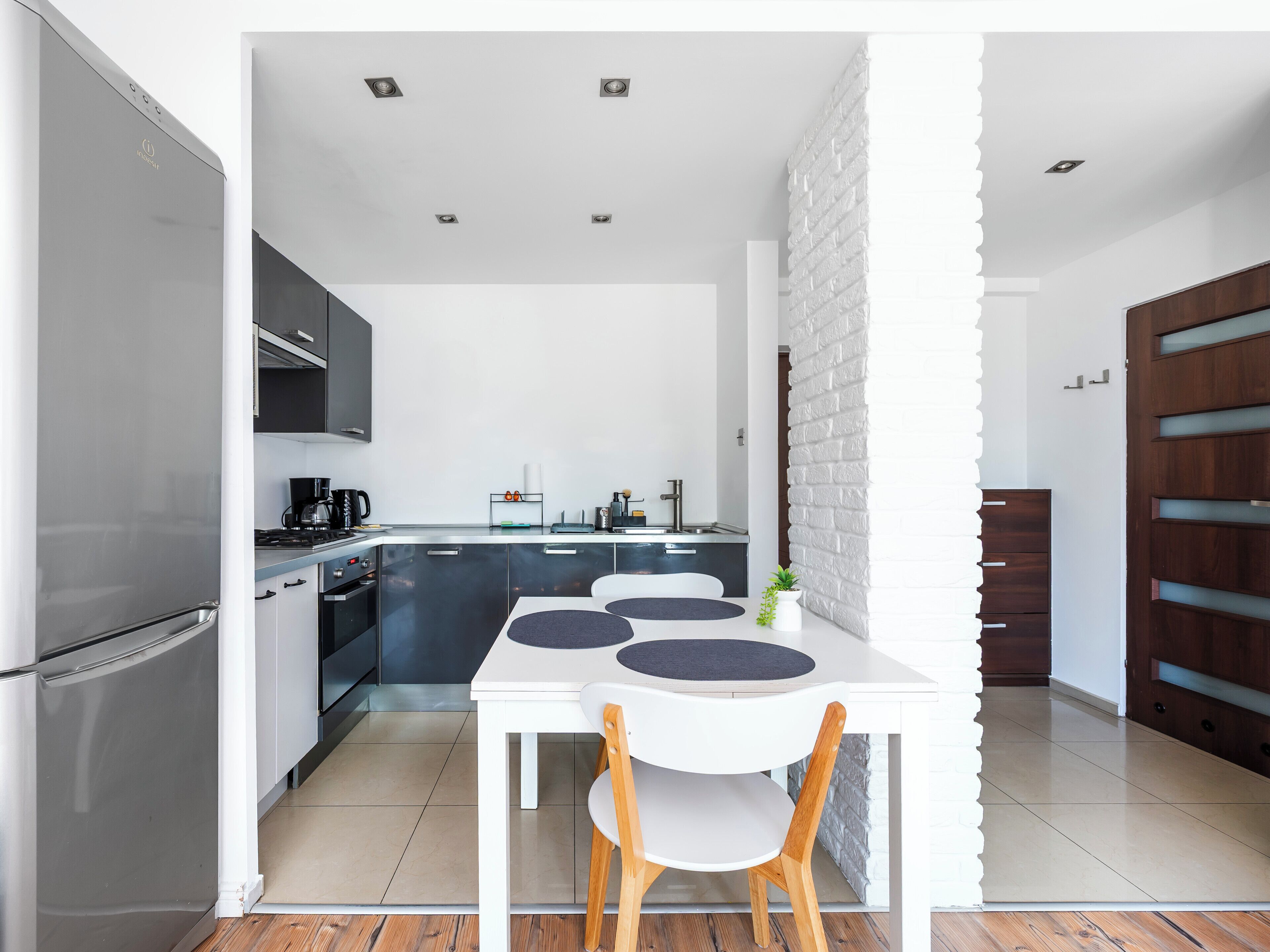 Een moderne keuken met een eethoek, voorzien van een koelkast, fornuis en kasten.