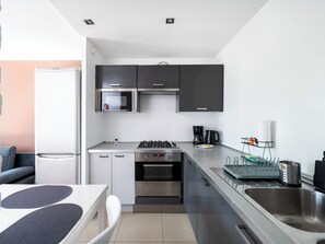 Une cuisine moderne équipée d’un four à micro-ondes, d’un four traditionnel et d’une cuisinière à gaz.