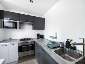 Una cocina moderna con microondas, horno y cocina a gas integrados.
