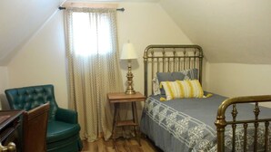 A bedroom with a bed, a chair, a nightstand, and a window with curtains. - Three Bedroom Cabin Escape near Dolores River on Private 300 Acre Ranch! (Dolores)