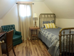 A bedroom with a bed, a chair, a nightstand, and a window with curtains. - Three Bedroom Cabin Escape near Dolores River on Private 300 Acre Ranch! (Dolores)