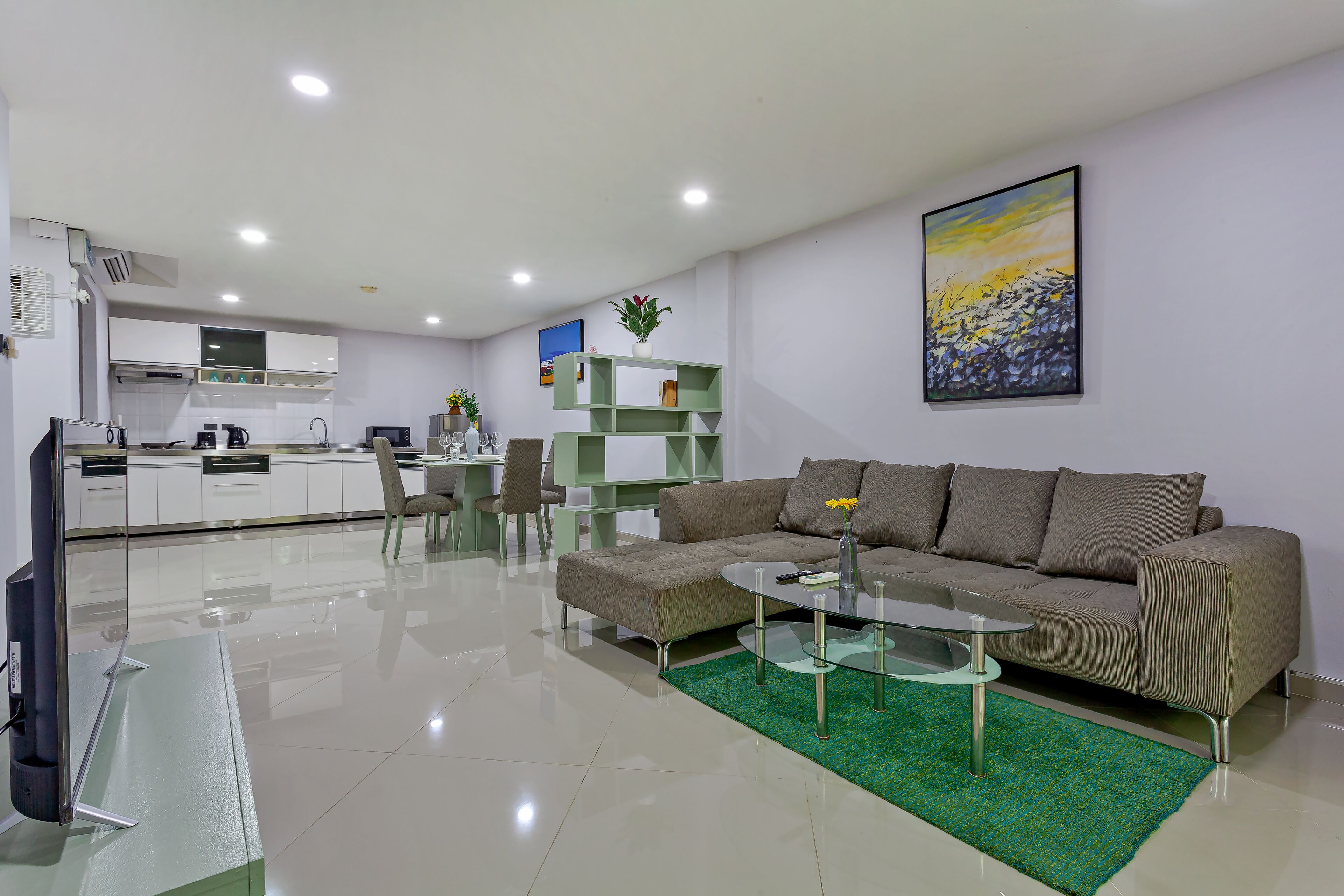 A modern living room with a sofa, coffee table, and a dining area with chairs and a table.