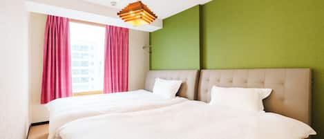 Una habitación de hotel con una cama grande, una ventana con cortinas y una lámpara de techo original.