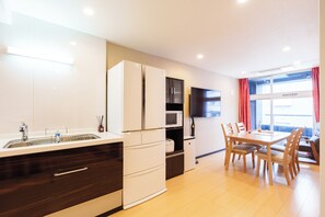 Eine moderne Küche mit integriertem Mikrowellenherd, Spüle und Essbereich mit Holzstühlen und einem Tisch.